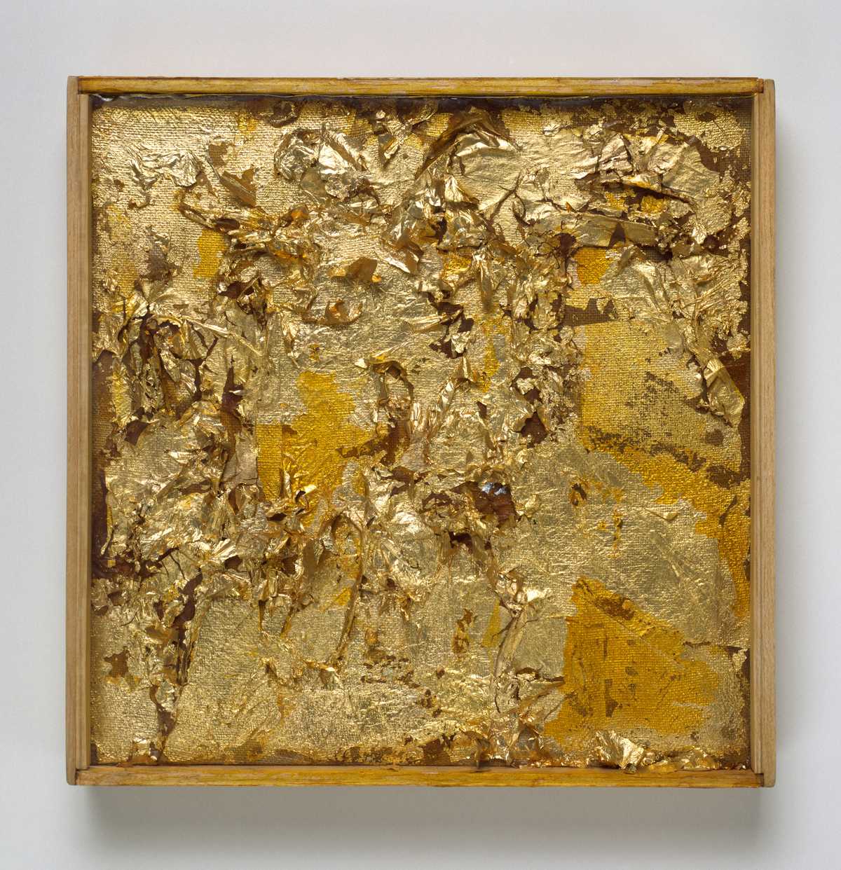 A square work of art with flaking gold leaf on a canvas