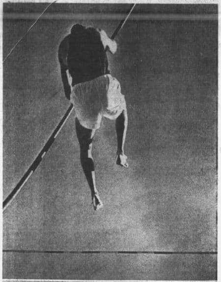 A newspaper photograph of a man in the process of pole vaulting